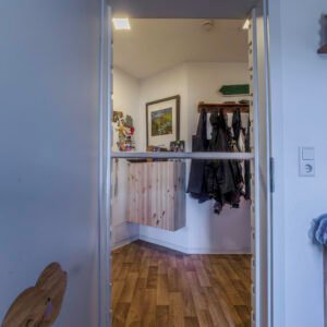 Klimmrahmen mit Sprosse auf mittlerer Höhe im Türrahmen zwischen Flur und Garderobe